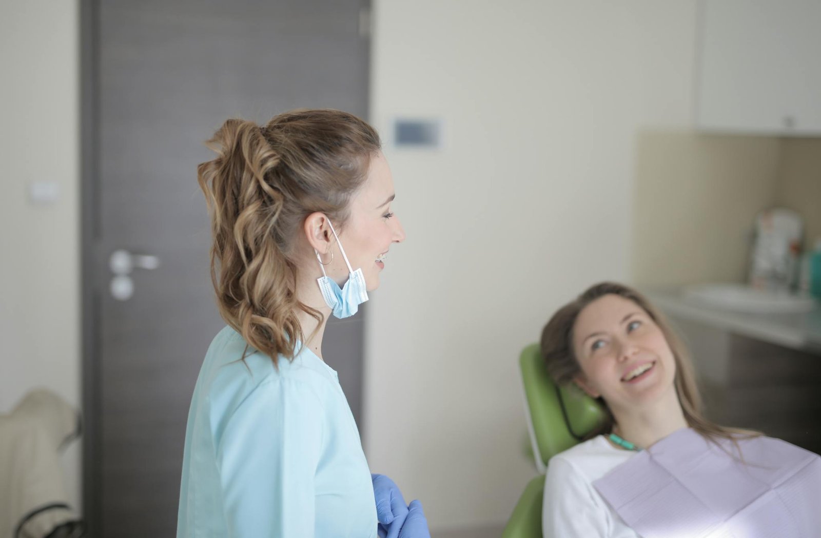 Dentist and patient sharing a positive interaction during a dental checkup session indoors.